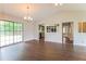 Open living room with hardwood floors, leading to kitchen, and large glass sliding doors at 10448 Sw 74Th Ct, Ocala, FL 34476