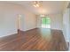 Open living room with hardwood floors, large windows, glass sliding doors, and high vaulted ceiling at 10448 Sw 74Th Ct, Ocala, FL 34476