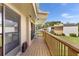 A serene outdoor balcony featuring wood floors, railings, and sliding glass doors for seamless indoor/outdoor living at 1051 S Highland St # 7D, Mount Dora, FL 32757