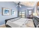 Comfortable bedroom featuring vaulted ceiling, blue walls, and natural light that streams in through a window at 1051 S Highland St # 7D, Mount Dora, FL 32757
