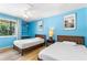 Bedroom featuring two beds, a built-in shelf, and bright blue painted walls at 1051 S Highland St # 7D, Mount Dora, FL 32757
