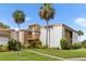 Condo exterior with manicured landscaping and palm trees against a blue sky at 1051 S Highland St # 7D, Mount Dora, FL 32757