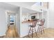 Charming kitchen with white cabinetry, wood countertop, and a breakfast bar with two wooden chairs at 1051 S Highland St # 7D, Mount Dora, FL 32757