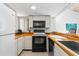 Well-equipped kitchen boasts modern appliances, including a black microwave and stove, paired with light countertops at 1051 S Highland St # 7D, Mount Dora, FL 32757
