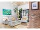 Light filled living room, showcasing vaulted ceiling, brick fireplace and seating area at 1051 S Highland St # 7D, Mount Dora, FL 32757