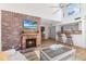 Open-concept living room with bar seating and a brick fireplace at 1051 S Highland St # 7D, Mount Dora, FL 32757