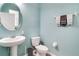 Cozy bathroom features blue walls, pedestal sink, toilet, and decorative towel rack at 14460 Orchard Hills Blvd, Winter Garden, FL 34787