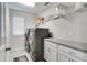 Well-equipped laundry room with modern washer and dryer, ample storage and shelving for organization at 14460 Orchard Hills Blvd, Winter Garden, FL 34787