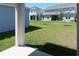 Backyard area with a green lawn, newly planted trees, and views of neighboring homes at 14568 Crestavista Ave, Clermont, FL 34714
