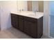 Elegant bathroom featuring double vanity with white countertops and dark wood cabinets at 14568 Crestavista Ave, Clermont, FL 34714