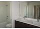 Bathroom with double sink vanity, framed mirror, and a shower/tub with white wall tile at 14568 Crestavista Ave, Clermont, FL 34714