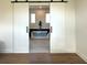 Elegant bathroom featuring a modern soaking tub with a clear glass side, accessed through white sliding barn doors at 1733 Harmon Ave, Winter Park, FL 32789