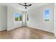 Bright bedroom featuring three windows, wood floor, ceiling fan, and white trim at 1733 Harmon Ave, Winter Park, FL 32789
