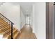 Hallway with modern staircase, hardwood floors, leading to a white front door at 1733 Harmon Ave, Winter Park, FL 32789