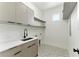 Laundry room with sink, storage cabinets, open shelving, and patterned tile flooring at 1733 Harmon Ave, Winter Park, FL 32789