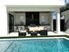 A covered outdoor kitchen and lounge area sits next to a sparkling pool at 1733 Harmon Ave, Winter Park, FL 32789
