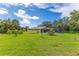Backyard with spacious lawn, mature landscaping, and a screened-in pool enclosure at 1879 Odham Dr, Deltona, FL 32738