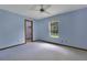 Simple bedroom with a view of a walk-in closet, blue walls, and a ceiling fan at 1879 Odham Dr, Deltona, FL 32738