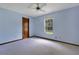 Cozy bedroom with light blue walls, a white ceiling fan, and natural light from the window at 1879 Odham Dr, Deltona, FL 32738