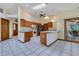 Eat-in kitchen featuring granite counters, white tile floors, stainless appliances, and backyard access at 1879 Odham Dr, Deltona, FL 32738