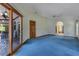 Bright living area with blue carpet, ceiling fan, and sliding glass door to the patio at 1879 Odham Dr, Deltona, FL 32738