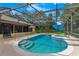 Inviting pool with a spa, surrounded by a screened enclosure and lush landscaping at 1879 Odham Dr, Deltona, FL 32738