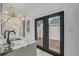 Modern bathroom featuring a marble vanity, tiled shower, and black framed doors leading to the outside at 1921 Heathwood Dr, Winter Park, FL 32792