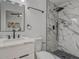 Modern bathroom with marble-look shower, vanity with sleek faucet, and stylish black hardware and mirror at 1921 Heathwood Dr, Winter Park, FL 32792