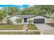 Charming one-story home featuring a well-manicured front yard, brick pathway, and a neatly painted garage door at 1921 Heathwood Dr, Winter Park, FL 32792