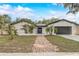 Charming single-Gathering home featuring a brick pathway, manicured front lawn, and an attached garage at 1921 Heathwood Dr, Winter Park, FL 32792