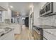Open kitchen showcasing marble counters and backsplash, stainless appliances, and wood-look floors at 1921 Heathwood Dr, Winter Park, FL 32792