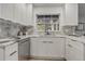 Bright kitchen with marble counters and backsplash plus stainless steel appliances and crisp white cabinets at 1921 Heathwood Dr, Winter Park, FL 32792