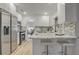 Modern kitchen features marble countertops and backsplash, stainless steel appliances and sleek, white cabinets at 1921 Heathwood Dr, Winter Park, FL 32792