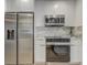 Kitchen with stainless steel fridge and stove plus marble backsplash and countertops and bright white cabinets at 1921 Heathwood Dr, Winter Park, FL 32792