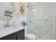Bathroom with a modern vanity, round mirror, and glass-enclosed shower with marble-style tile at 1926 Natalen Rd, Winter Park, FL 32792