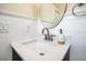 Stylish bathroom featuring a modern sink, round mirror, and wainscoting detail at 1926 Natalen Rd, Winter Park, FL 32792