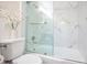 Bathroom with a toilet and a tub with a glass enclosure featuring gold accents at 1926 Natalen Rd, Winter Park, FL 32792