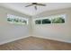 This bright bedroom features hardwood floors, two windows, and a ceiling fan at 1926 Natalen Rd, Winter Park, FL 32792