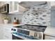 Close-up of a modern kitchen stove with a stylish tile backsplash and stainless steel range hood at 1926 Natalen Rd, Winter Park, FL 32792