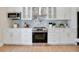 Contemporary kitchen features stainless steel appliances, white cabinetry, and an island with a breakfast bar at 1926 Natalen Rd, Winter Park, FL 32792