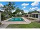 Backyard pool view featuring a seating area, tropical landscaping, and a wooden privacy fence at 1926 Natalen Rd, Winter Park, FL 32792