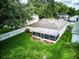 Backyard featuring a screened lanai, landscaped beds, and lush grass at 2031 Wekiva Reserve Blvd, Apopka, FL 32703