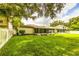 View of a lush backyard with a screened-in porch and manicured lawn at 2031 Wekiva Reserve Blvd, Apopka, FL 32703