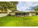 Well-maintained backyard featuring a screened-in patio, lush lawn, and mature landscaping at 2031 Wekiva Reserve Blvd, Apopka, FL 32703