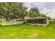 Spacious backyard featuring a screened-in porch, green lawn, and privacy fence at 2031 Wekiva Reserve Blvd, Apopka, FL 32703
