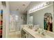 Clean primary bathroom with dual sinks, a large mirror, and a walk-in closet at 2031 Wekiva Reserve Blvd, Apopka, FL 32703