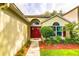 Welcoming entrance with vibrant red double doors, surrounded by lush, green landscaping at 2031 Wekiva Reserve Blvd, Apopka, FL 32703