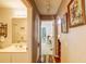 Hallway view showcasing hardwood floors, wall art, and an open view to a bathroom and another room at 2031 Wekiva Reserve Blvd, Apopka, FL 32703
