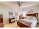 Comfortable bedroom with ceiling fan, window, and wooden furniture. Door to hallway is open at 2031 Wekiva Reserve Blvd, Apopka, FL 32703