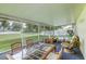 Enclosed patio with wicker furniture and a glass top table overlooking the backyard at 2031 Wekiva Reserve Blvd, Apopka, FL 32703